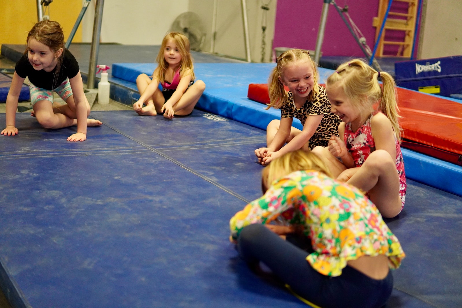 a group of girls sitting on a mat